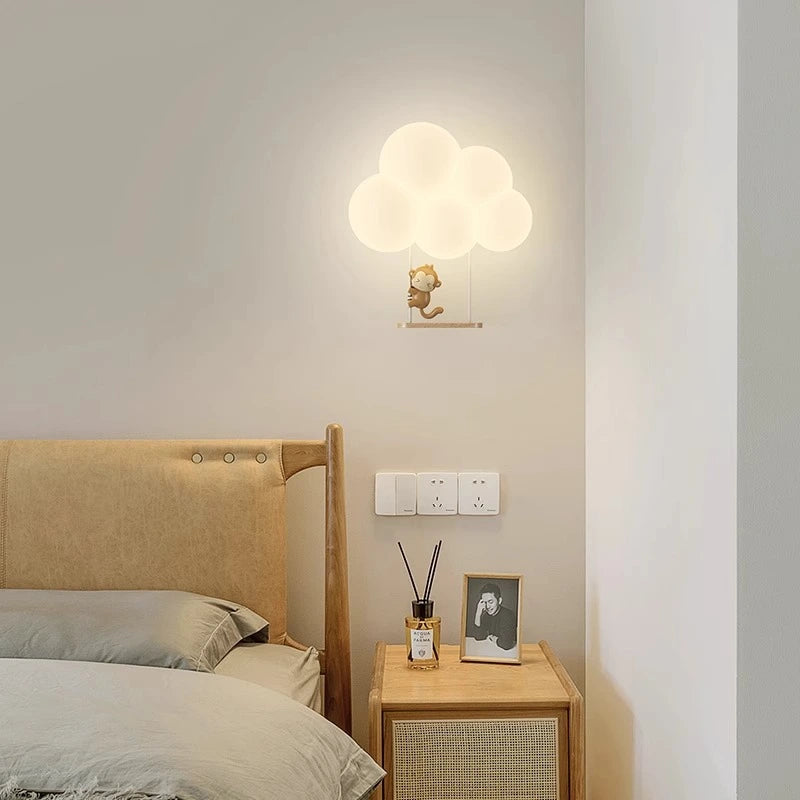 Applique murale en forme de nuage avec un singe allumée dans une chambre d'enfant